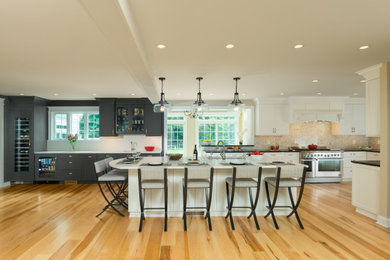 Example of a huge transitional l-shaped medium tone wood floor and brown floor eat-in kitchen design in Boston with an undermount sink, shaker cabinets, quartz countertops, gray backsplash, cement tile backsplash, stainless steel appliances and an island