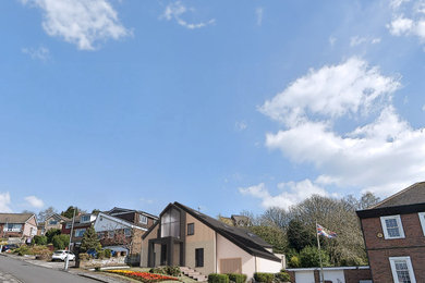 Imagen de fachada de casa multicolor y negra actual grande de dos plantas con revestimiento de madera, tejado a dos aguas, tejado de teja de barro y panel y listón