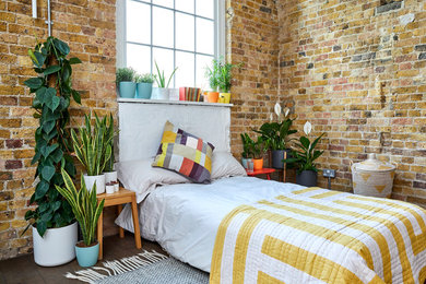 Inspiration for an industrial bedroom in London with dark hardwood floors and brown floor.