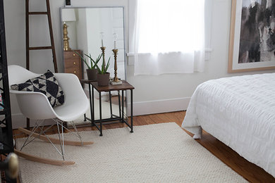 This is an example of a small eclectic master bedroom in Other with white walls, medium hardwood floors and no fireplace.
