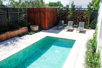 Photo of a mid-sized contemporary backyard rectangular pool in Melbourne with with a pool and natural stone pavers.