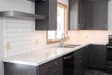 Eat-in kitchen - mid-sized modern u-shaped vinyl floor and gray floor eat-in kitchen idea in Other with a drop-in sink, flat-panel cabinets, dark wood cabinets, laminate countertops, white backsplash, subway tile backsplash, black appliances, an island and white countertops