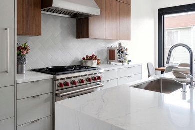 Mid-sized minimalist single-wall medium tone wood floor and brown floor eat-in kitchen photo in San Francisco with a drop-in sink, flat-panel cabinets, gray cabinets, quartz countertops, gray backsplash, porcelain backsplash, stainless steel appliances, an island and white countertops