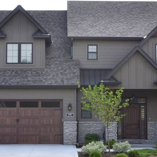 Bild på ett mellanstort amerikanskt grått hus, med två våningar, vinylfasad, halvvalmat sadeltak och tak i shingel