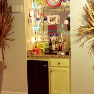 他の地域のビーチスタイルのおしゃれなバーカート (落し込みパネル扉のキャビネット、黄色いキャビネット、御影石カウンター、ガラスタイルのキッチンパネル、ベージュのキッチンカウンター) の写真