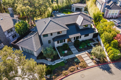 На фото: серый дом в стиле модернизм с облицовкой из цементной штукатурки, металлической крышей и отделкой планкеном