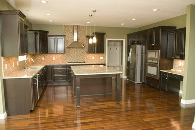 Mid-sized transitional u-shaped dark wood floor and brown floor eat-in kitchen photo in Other with an undermount sink, recessed-panel cabinets, dark wood cabinets, granite countertops, multicolored backsplash, mosaic tile backsplash, stainless steel appliances and an island