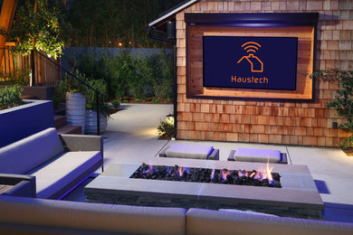 Design ideas for a large contemporary backyard patio in Los Angeles with a fire feature, concrete slab and a pergola.