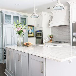 Идея дизайна: п-образная кухня среднего размера в стиле кантри с раковиной в стиле кантри, фасадами в стиле шейкер, белыми фасадами, фартуком из керамической плитки, техникой из нержавеющей стали, островом, коричневым полом, серым фартуком, кладовкой, столешницей из кварцита, паркетным полом среднего тона и серой столешницей