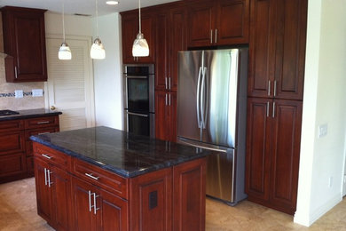 Kitchen - mid-sized traditional ceramic tile kitchen idea in San Diego with an undermount sink, raised-panel cabinets, dark wood cabinets, beige backsplash, stainless steel appliances and an island