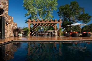 Large country backyard rectangular natural pool in Albuquerque with natural stone pavers.