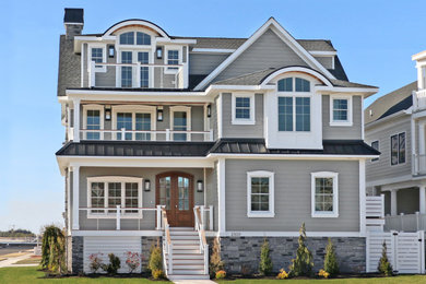 Large trendy gray three-story concrete fiberboard house exterior photo in Philadelphia with a hip roof and a mixed material roof