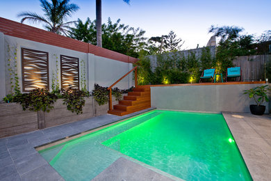 Photo of a large modern backyard pool in Perth with brick pavers.
