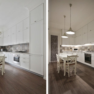 Design ideas for a mid-sized country l-shaped open plan kitchen in Other with a drop-in sink, recessed-panel cabinets, white cabinets, quartzite benchtops, multi-coloured splashback, ceramic splashback, black appliances, porcelain floors, no island, grey floor and pink benchtop.