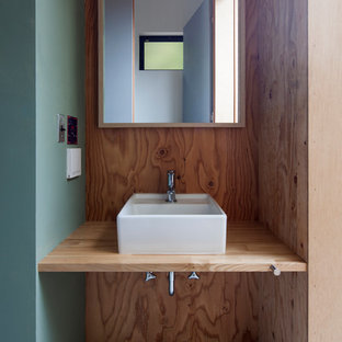 Immagine di un piccolo bagno di servizio minimalista con pareti verdi, lavabo a bacinella e pavimento grigio