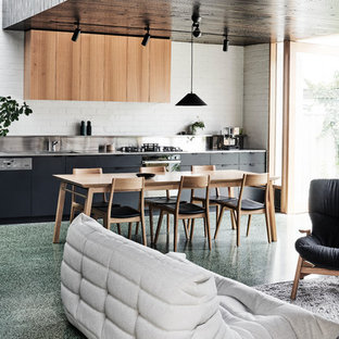 Aménagement d'une salle à manger ouverte sur le salon moderne de taille moyenne avec un mur blanc, béton au sol, aucune cheminée et un sol vert.