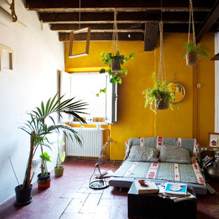 Mittelgroßes, Fernseherloses, Offenes Mediterranes Wohnzimmer ohne Kamin mit Terrakottaboden, rotem Boden und gelber Wandfarbe in Sonstige