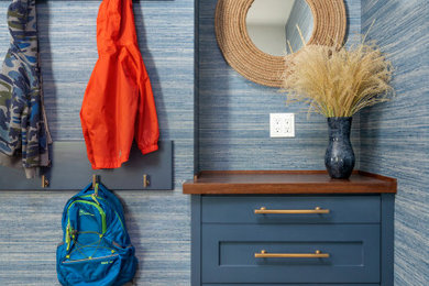 Example of a mid-sized cottage dark wood floor, brown floor and wallpaper mudroom design in New York with blue walls