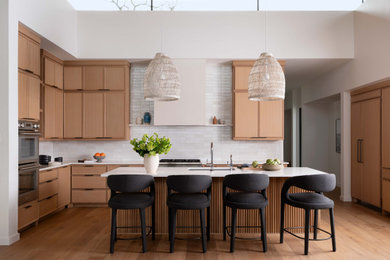 Inspiration for a contemporary u-shaped light wood floor and beige floor kitchen remodel in Austin with an undermount sink, recessed-panel cabinets, light wood cabinets, white backsplash, stainless steel appliances, an island and white countertops