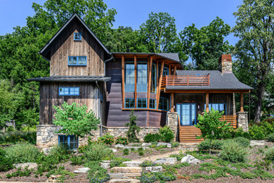 Rustic brown three-story mixed siding exterior home idea in Other with a mixed material roof
