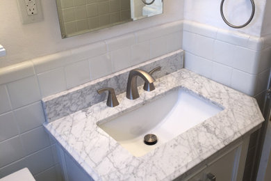 Example of a transitional white tile and ceramic tile laminate floor and gray floor bathroom design in St Louis with furniture-like cabinets, gray cabinets, marble countertops and white countertops