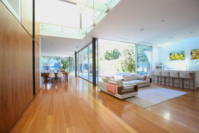 Large contemporary hallway in Sydney with white walls, light hardwood floors and brown floor.