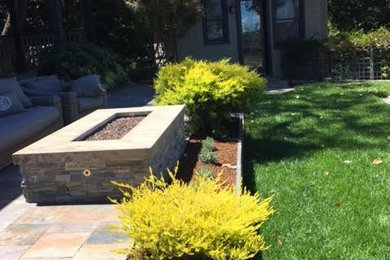 Mid-sized elegant backyard tile patio photo in San Francisco with a fire pit and a roof extension
