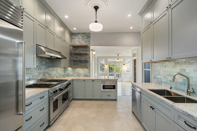 Photo of a large victorian l-shaped kitchen/diner in San Francisco with a double-bowl sink, recessed-panel cabinets, grey cabinets, granite worktops, green splashback, glass tiled splashback, stainless steel appliances, an island, grey worktops, ceramic flooring, beige floors and a coffered ceiling.