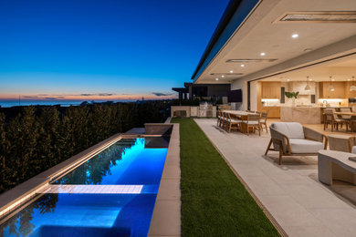 Large trendy backyard stone and rectangular pool photo in Orange County with a bbq area