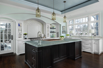 Inspiration for a large timeless l-shaped dark wood floor and brown floor enclosed kitchen remodel in Detroit with a farmhouse sink, white cabinets, marble countertops, white backsplash, stainless steel appliances, an island, white countertops, shaker cabinets and subway tile backsplash