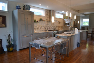 Open concept kitchen - large transitional l-shaped medium tone wood floor open concept kitchen idea in Cincinnati with an undermount sink, gray cabinets, granite countertops, multicolored backsplash, mosaic tile backsplash, stainless steel appliances, an island and beaded inset cabinets