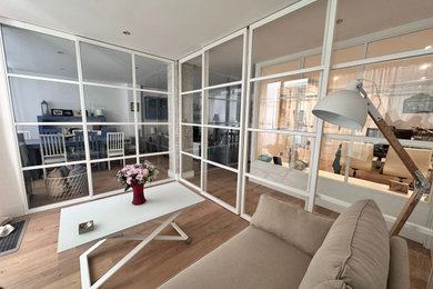 Modelo de salón abierto y blanco y madera minimalista de tamaño medio con paredes blancas, suelo de madera en tonos medios y suelo marrón