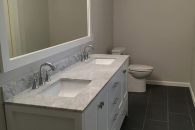 Trendy master white tile porcelain tile alcove shower photo in Austin with shaker cabinets, white cabinets, an undermount sink, marble countertops and beige walls