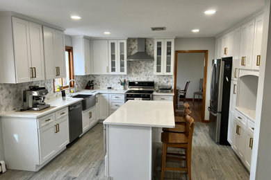 Kitchen - transitional porcelain tile, gray floor and vaulted ceiling kitchen idea in New York with a farmhouse sink, shaker cabinets, white cabinets, quartz countertops, white backsplash, marble backsplash, stainless steel appliances, an island and white countertops