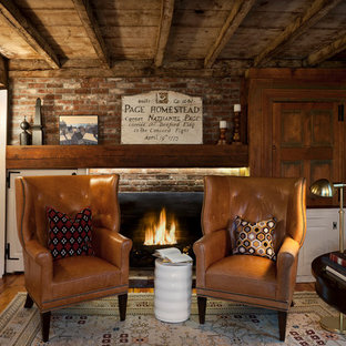 Ejemplo de despacho rural, de tamaño medio, con marco de chimenea de ladrillo, paredes blancas, suelo de madera en tonos medios, chimenea tradicional y escritorio independiente