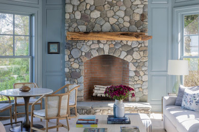 Large beach style slate floor sunroom photo in Boston with a standard fireplace and a stacked stone fireplace