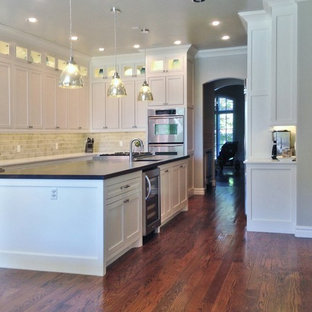 Large eclectic kitchen pantry designs - Inspiration for a large eclectic l-shaped medium tone wood floor kitchen pantry remodel in Oklahoma City with an undermount sink, beaded inset cabinets, white cabinets, wood countertops, beige backsplash, subway tile backsplash, stainless steel appliances and an island