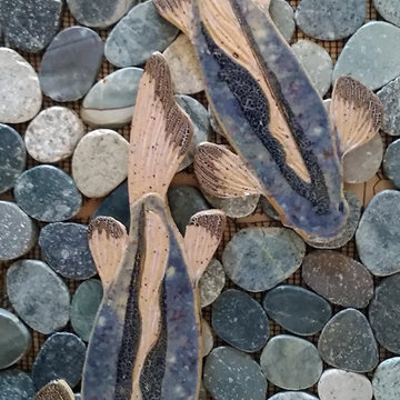 Blue largemouth bass fish over sliced ocean pebble tiles