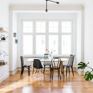 Geschlossenes, Mittelgroßes Nordisches Esszimmer mit weißer Wandfarbe, hellem Holzboden und braunem Boden in Berlin