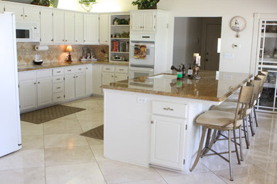 Example of a large l-shaped ceramic tile open concept kitchen design in Houston with an undermount sink, white cabinets, beige backsplash, mosaic tile backsplash, stainless steel appliances and an island