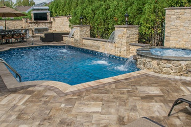 This is an example of a mid-sized contemporary backyard custom-shaped pool in New York with a hot tub and concrete pavers.