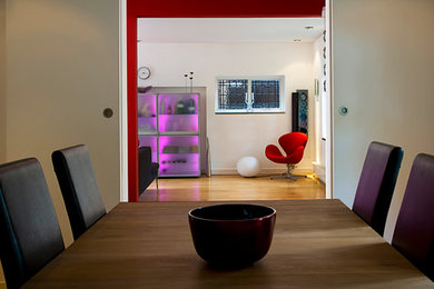 Design ideas for a medium sized contemporary dining room in London with medium hardwood flooring and white walls.