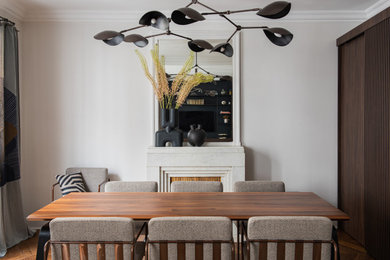 Réalisation d'une grande salle à manger ouverte sur le salon design en bois avec un mur blanc, une cheminée standard et éclairage.