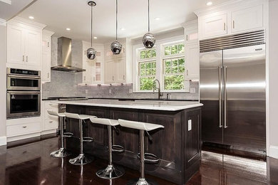 Photo of a mid-sized transitional l-shaped eat-in kitchen in Boston with white cabinets, quartz benchtops, white splashback, stone tile splashback, dark hardwood floors, with island, an undermount sink, flat-panel cabinets and stainless steel appliances.