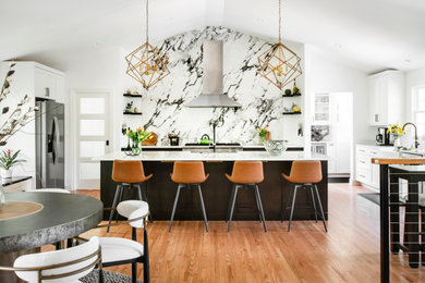Inspiration for a huge transitional u-shaped medium tone wood floor, brown floor and vaulted ceiling open concept kitchen remodel in Nashville with an undermount sink, recessed-panel cabinets, white cabinets, quartz countertops, white backsplash, porcelain backsplash, stainless steel appliances, an island and white countertops