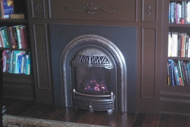 ポートランドにある高級な中くらいなヴィクトリアン調のおしゃれな書斎 (ベージュの壁、濃色無垢フローリング、標準型暖炉、木材の暖炉まわり、自立型机) の写真