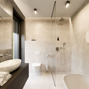 Esempio di una piccola stanza da bagno padronale minimalista con nessun'anta, vasca freestanding, doccia aperta, WC sospeso, piastrelle marroni, piastrelle in ceramica, pareti marroni, pavimento alla veneziana, lavabo integrato, top in legno, pavimento marrone, doccia aperta e top grigio