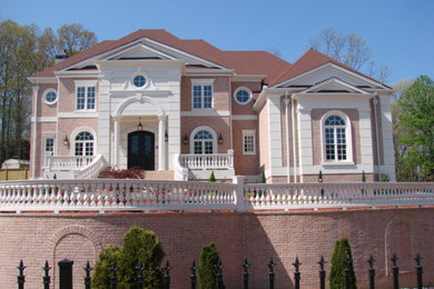 Large elegant brown two-story brick exterior home photo in Atlanta with a hip roof