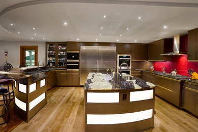 Large trendy u-shaped light wood floor eat-in kitchen photo in Cleveland with an undermount sink, flat-panel cabinets, gray cabinets, granite countertops, metallic backsplash, glass sheet backsplash, stainless steel appliances, an island and multicolored countertops