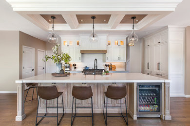 Example of a mid-sized beach style medium tone wood floor and tray ceiling kitchen design in Detroit with white backsplash, quartz backsplash, paneled appliances, an island and white countertops